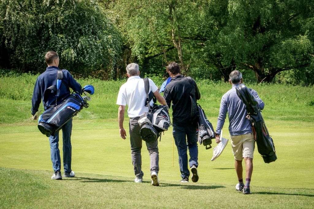 Golfers walking together towards the green at a golf club in High Wycombe